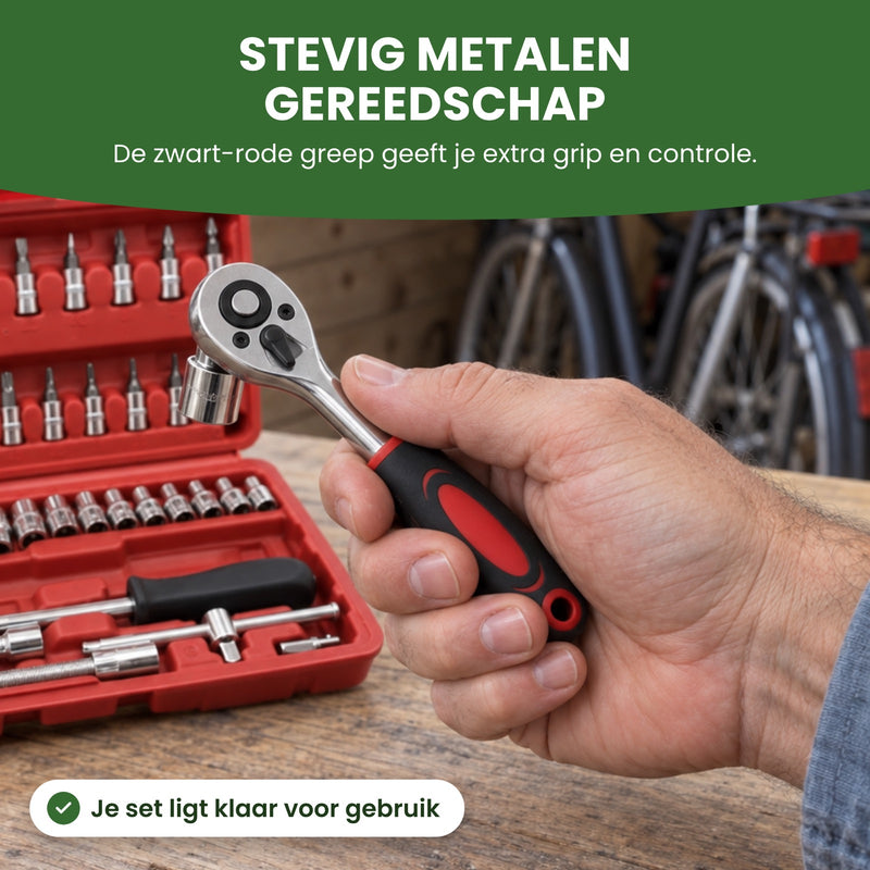 Hand houdt de ratel met zwart-rode greep en een dop erop boven de open rode koffer in de schuur: stevig metalen gereedschap met extra grip