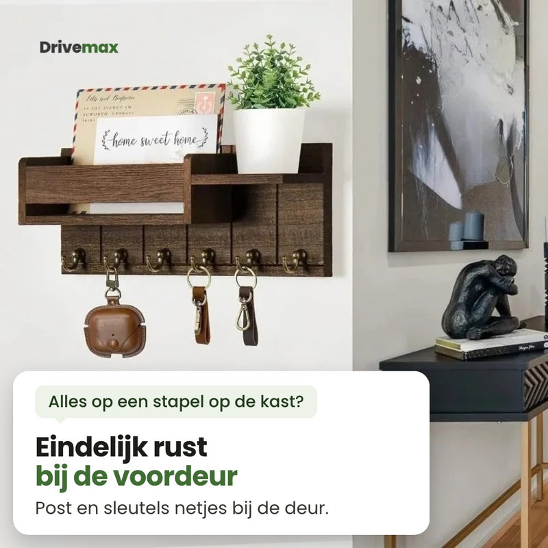 Het Entrova wandrek aan de muur naast een schilderij en een zwarte wandtafel, met post, een plantje en sleutels: eindelijk rust bij de voordeur