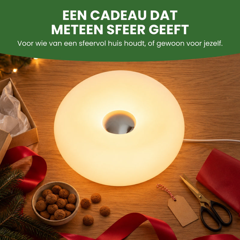 De Halova van boven op een salontafel tussen cadeaupapier, een lint en pepernoten: een cadeau dat meteen sfeer geeft