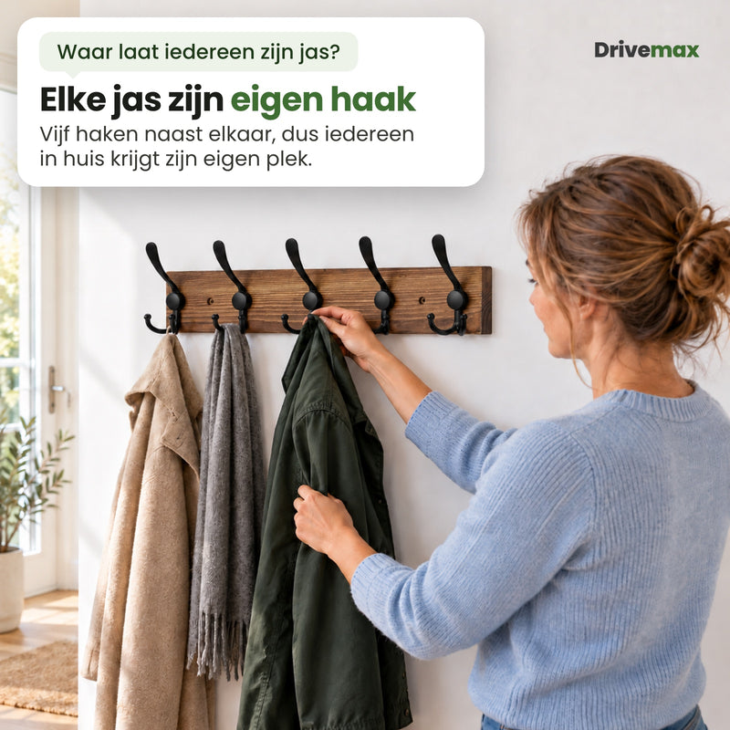 Een vrouw hangt haar groene jas aan de Kapova kapstok: vijf haken naast elkaar, voor iedereen in huis een eigen plek