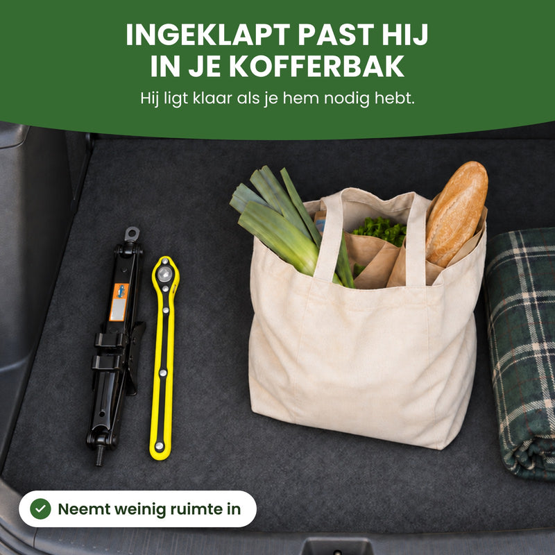 LiftMax autokrik ingeklapt met de ratelsleutel in een kofferbak naast een boodschappentas: ingeklapt past hij in je kofferbak