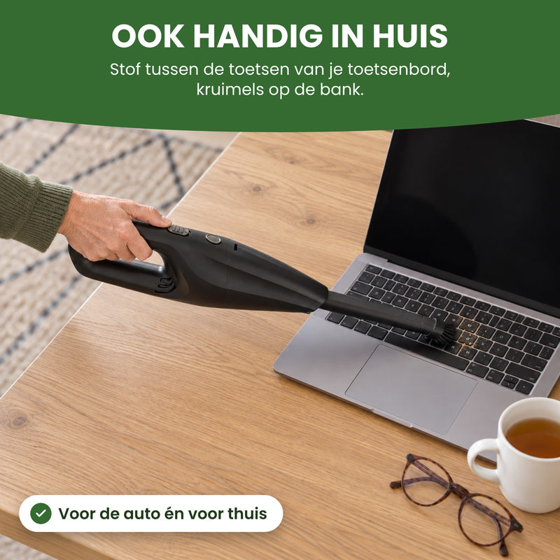 Neatix met lang mondstuk en borstel zuigt stof tussen de toetsen van een laptop op de eettafel: ook handig in huis