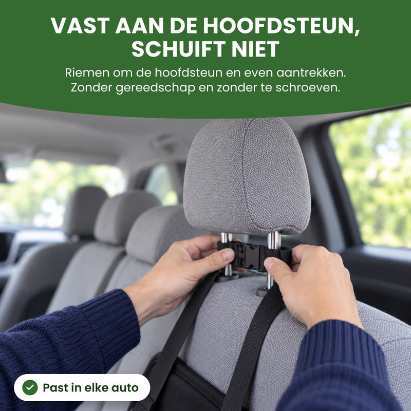 Twee handen klikken de gesp van de riemen van de PawComfort dicht om de hoofdsteun van de achterbank: vast aan de hoofdsteun, schuift niet