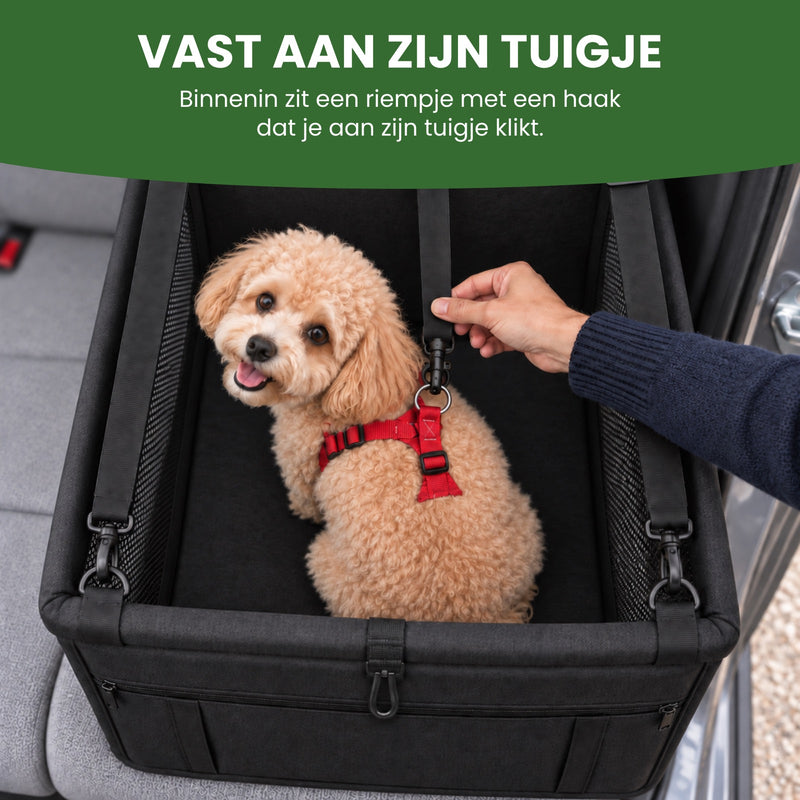 De haak van het riempje in de PawComfort zit aan het rode tuigje van het hondje, een hand houdt het riempje vast: vast aan zijn tuigje