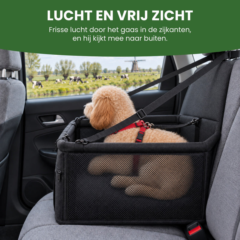 Hondje ligt in de PawComfort met gaas in de zijkant en kijkt door het autoraam naar de polder: frisse lucht en hij kijkt mee naar buiten