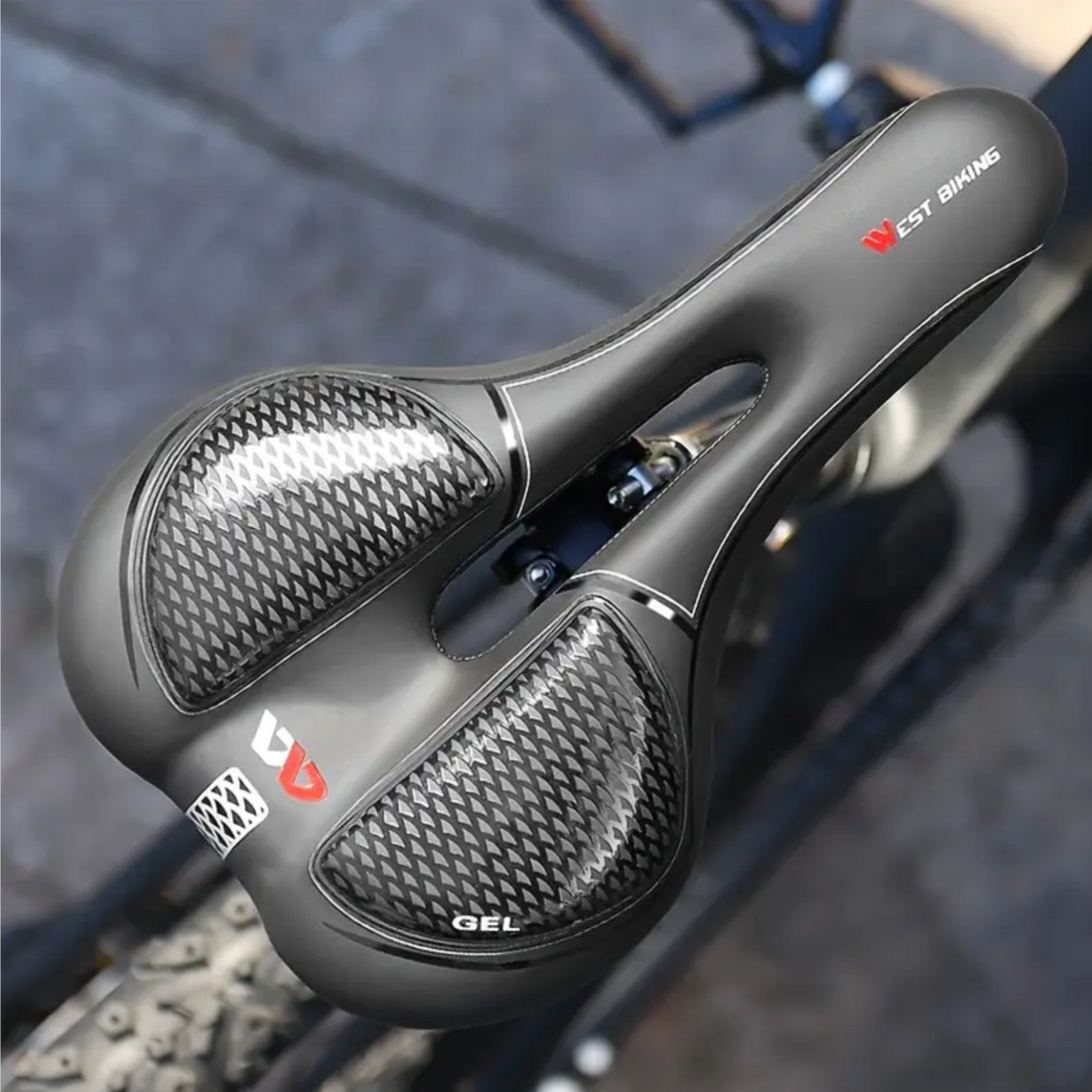 Zwart ergonomisch fietszadel met gel en ventilatie, gemonteerd op een carbon zadelpen.