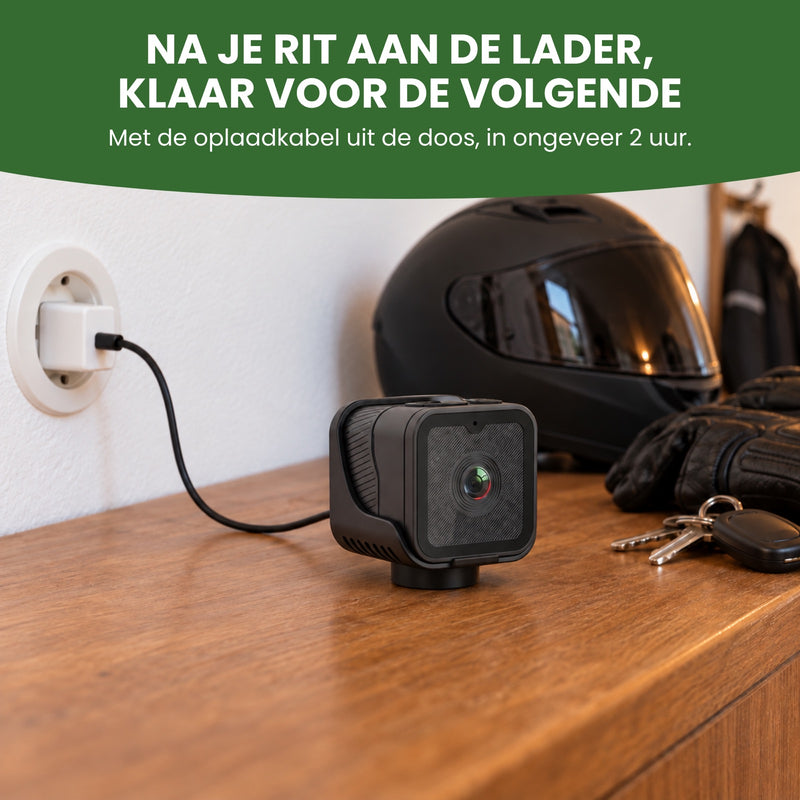 RideGuard Pro aan de oplaadkabel op een kast naast een helm en handschoenen: opladen met de kabel uit de doos, in ongeveer 2 uur
