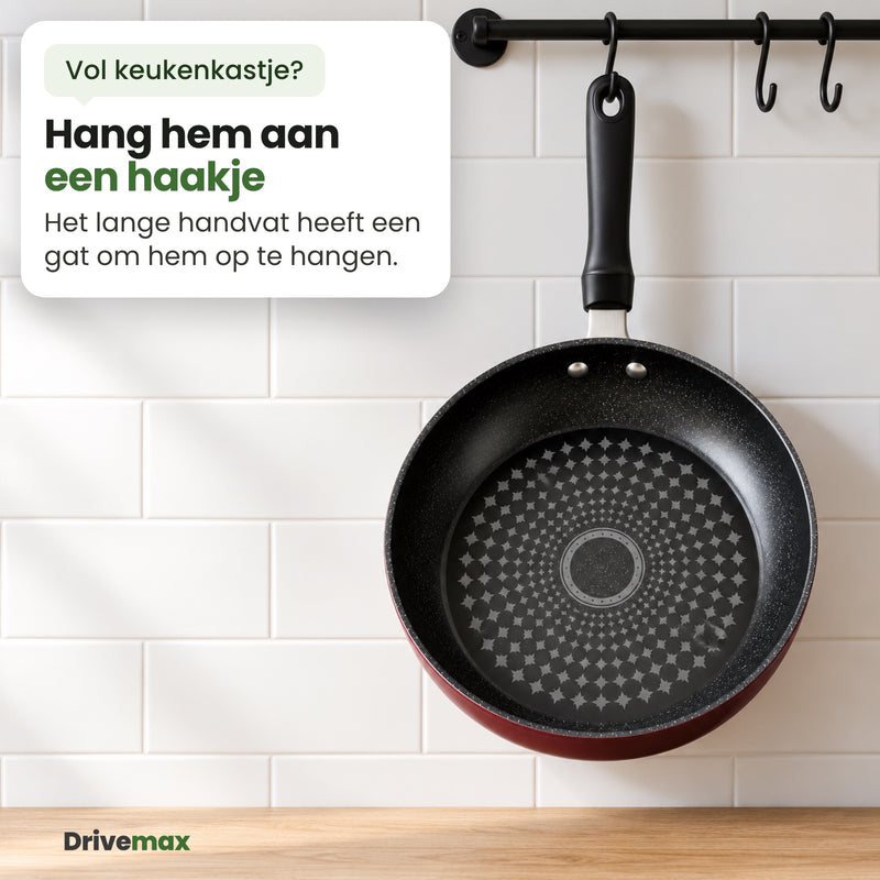 De Smulova koekenpan hangt met het gat in het handvat aan een haakje aan een zwarte stang op een witte tegelwand: hang hem aan een haakje