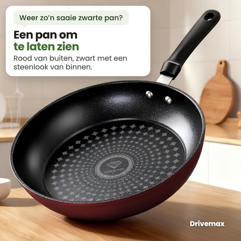 De Smulova koekenpan op een houten aanrecht in een lichte keuken: rood van buiten, zwart met een steenlook van binnen