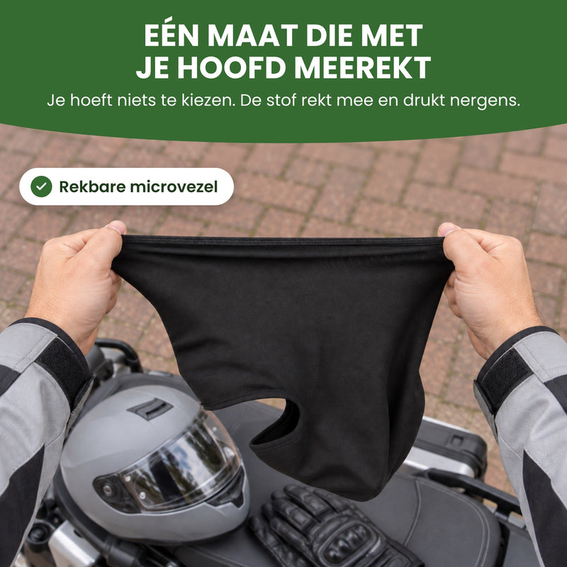 Twee handen rekken de ThermoShield balaclava ver uit boven een motorzadel met een helm: één maat die met je hoofd meerekt