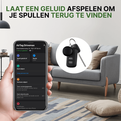 Zwarte TrackGuard gps-tracker aan autosleutelbos met locatie zichtbaar op smartphone in woonkamer.
