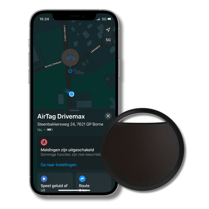 Zwarte TrackGuard gps-tracker naast smartphone met locatie op scherm zichtbaar.