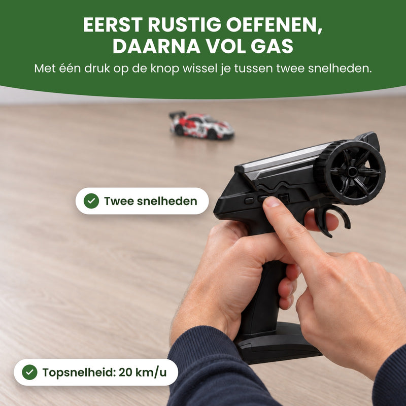 Vinger drukt op een knop van de afstandsbediening van de TurboRacer: met twee snelheden eerst rustig oefenen, daarna vol gas