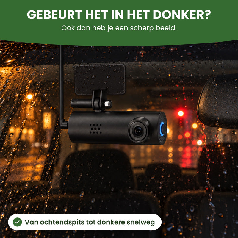 De VoiceGuard Pro dashcam achter een natte voorruit op een donkere avond, met het blauwe lichtje aan: ook in het donker een scherp beeld