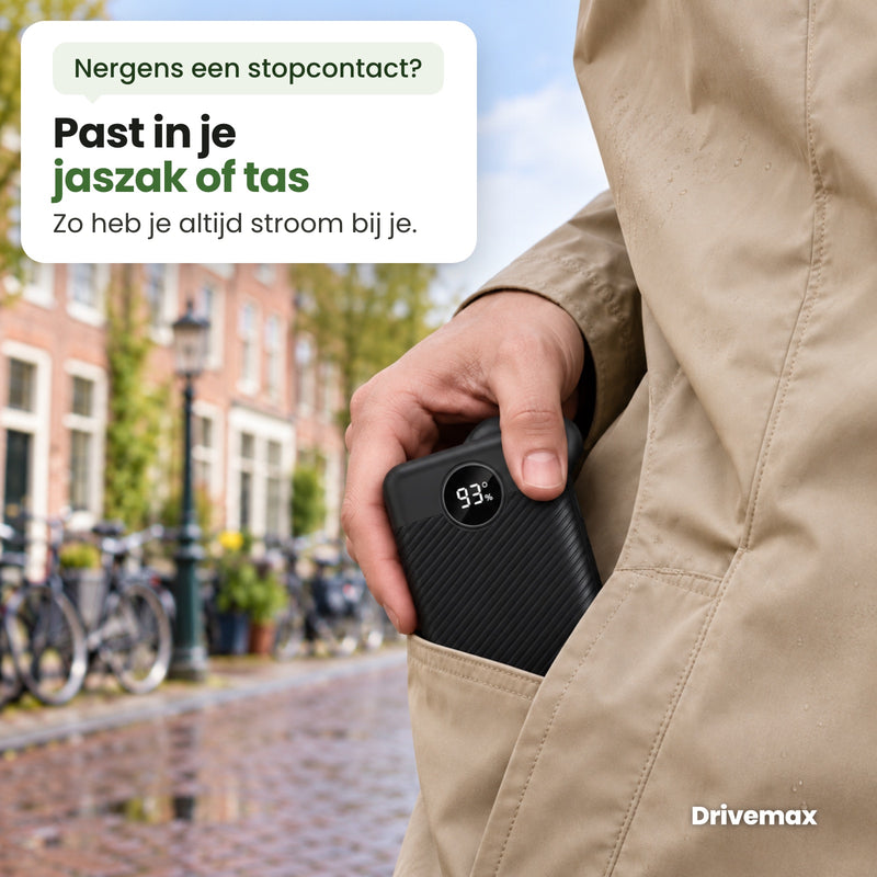 Iemand steekt de Voltova powerbank in de zak van een regenjas op een Nederlandse straat: past in je jaszak of tas