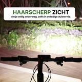 Fiets met ingeschakelde Voltura LED lamp verlicht helder een pad in het donker voor maximale zichtbaarheid.