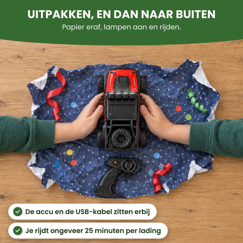 Twee kinderhanden pakken de rode VorteX uit op cadeaupapier, van boven gezien: papier eraf, lampen aan en rijden